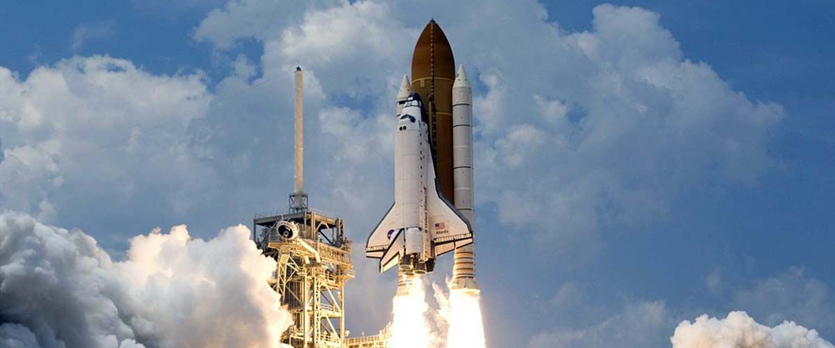 Liftoff eines Spaceshuttle mit mehreren Raketen bei Tag.