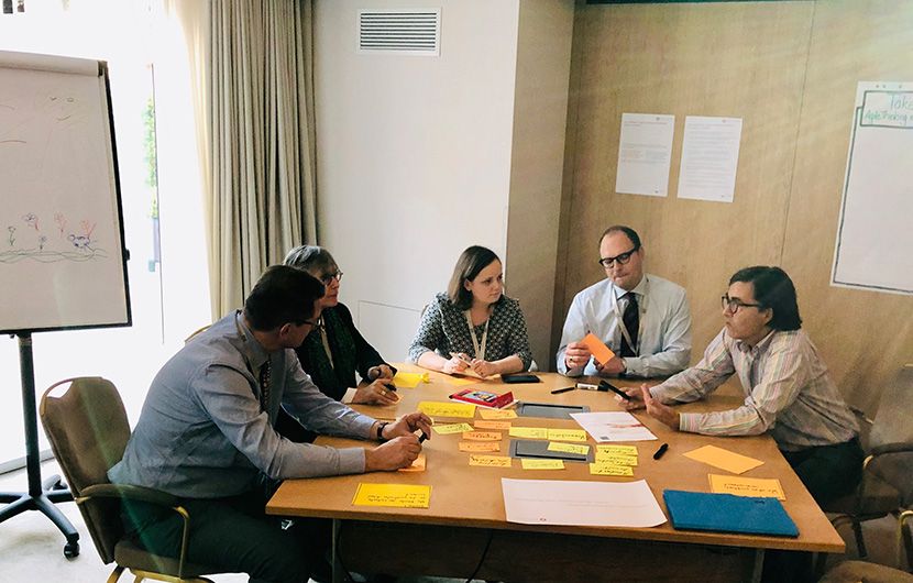 Eine Gruppen sitzt an einem Tisch und führt eine Diskussion