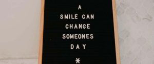 Ein Schild mit dem Schriftzug "A smile can change someones day"